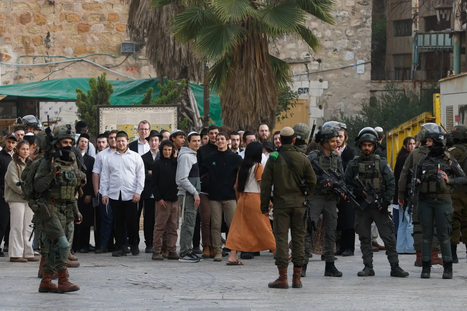 جنود إسرائيليون يقفون حراساً خلال جولة أسبوعية للمستوطنين في الخليل بالضفة الغربية (رويترز)