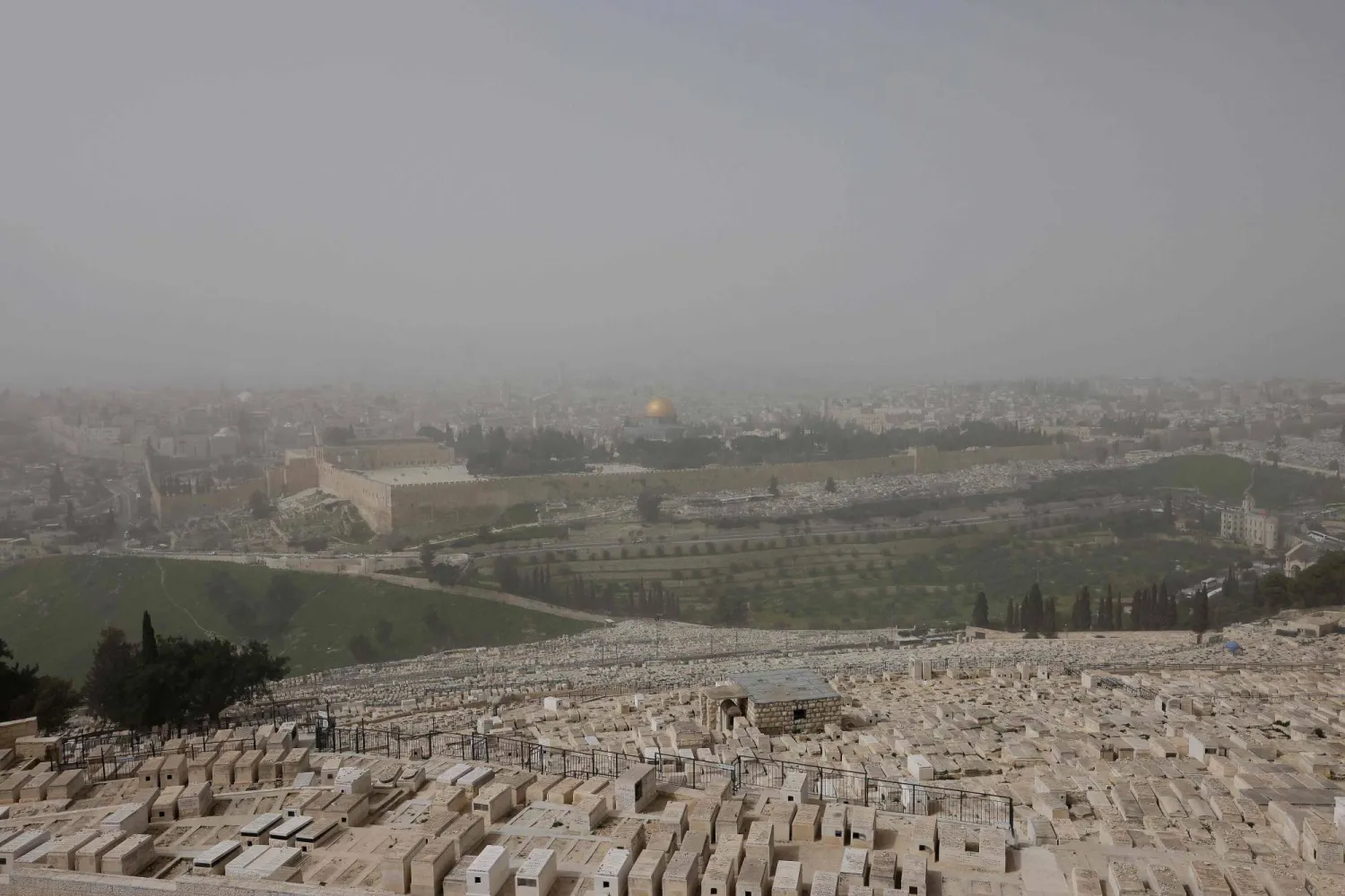 مقبرة جبل الزيتون اليهودية وفي الخلفية مجمّع المسجد الأقصى وقبة الصخرة في القدس (أ.ف.ب)