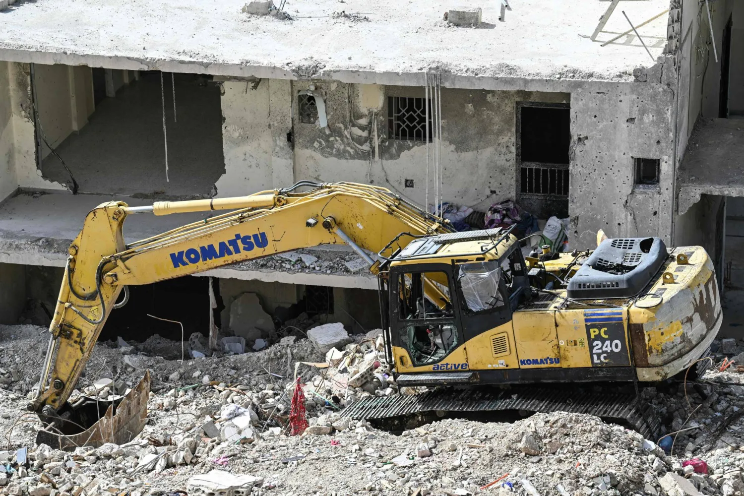 حفارة متضررة تقف على أنقاض مبنى تعرّض لضربة جوية إسرائيلية في قرية قناريت جنوب لبنان... 16 فبراير 2026 (أ.ف.ب)