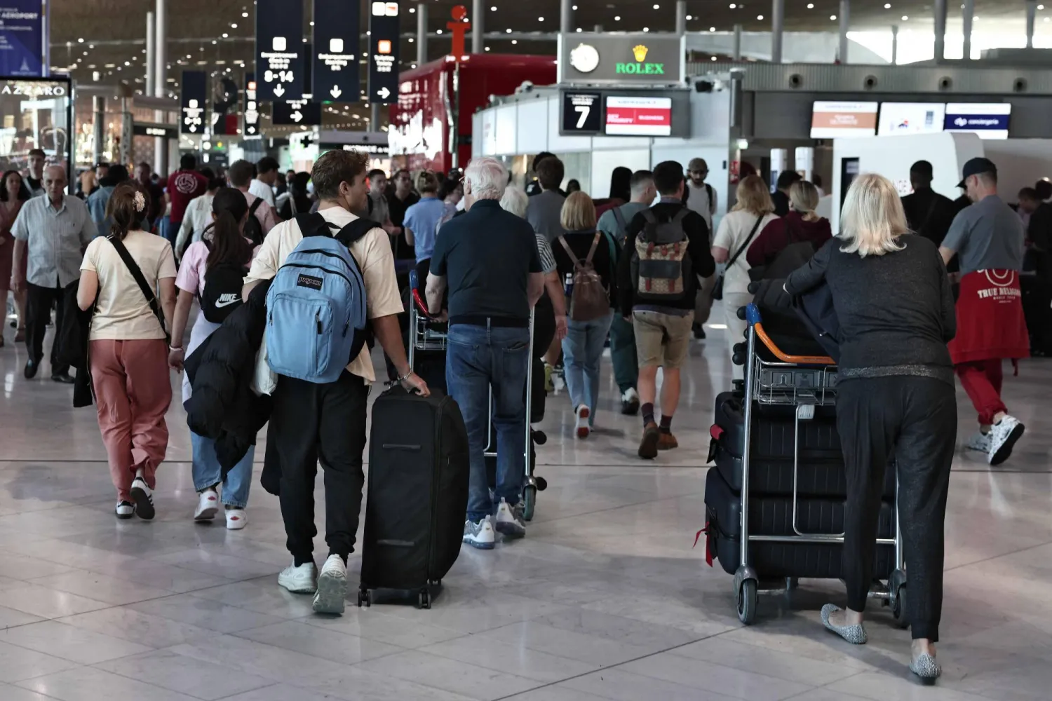 مسافرون عالقون في «مطار شارل ديغول» في العاصمة الفرنسية باريس وسط إضراب مراقبي حركة الملاحة الجوية (أ.ف.ب)