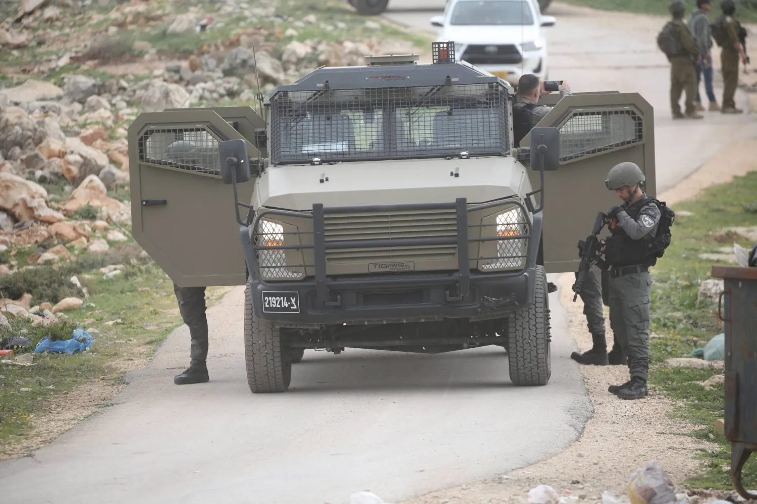 جنود إسرائيليون يؤمّنون الجرافات الإسرائيلية أثناء هدمها منزلاً فلسطينياً في نابلس بالضفة الغربية يوم الاثنين (د.ب.أ)