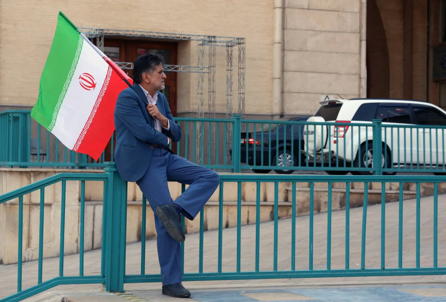 An Iranian man holds the Iranian national flag during a memorial ceremony for those killed in anti-government protests earlier last month, at the Mosalla mosque in Tehran, Iran, 17 February 2026. (EPA)