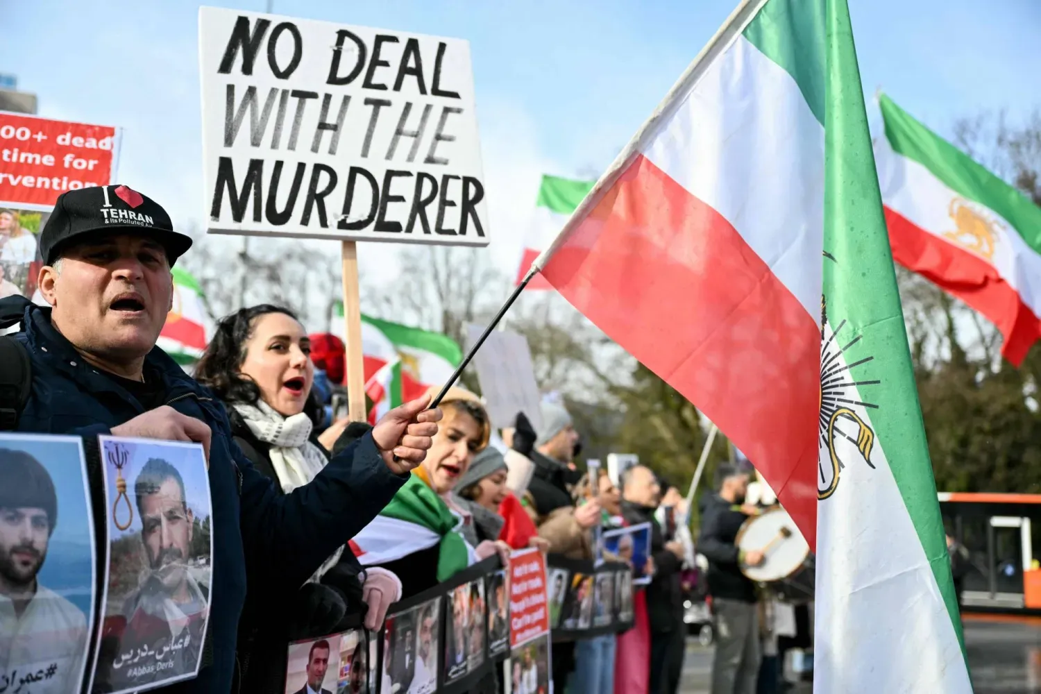 İran karşıtı protestocular, 17 Şubat 2026'da Cenevre'de ABD ve İran arasında başlayacak dolaylı nükleer görüşmeler öncesinde Birleşmiş Milletler ofisi önünde pankartlar ve resimler taşıdı (AFP)