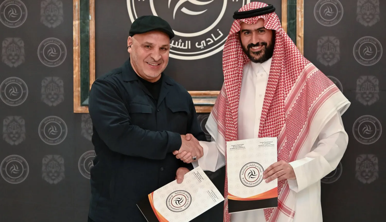 بن زكري يصافح عبد العزيز المالك رئيس الشباب بعد توقيع العقد (موقع النادي)