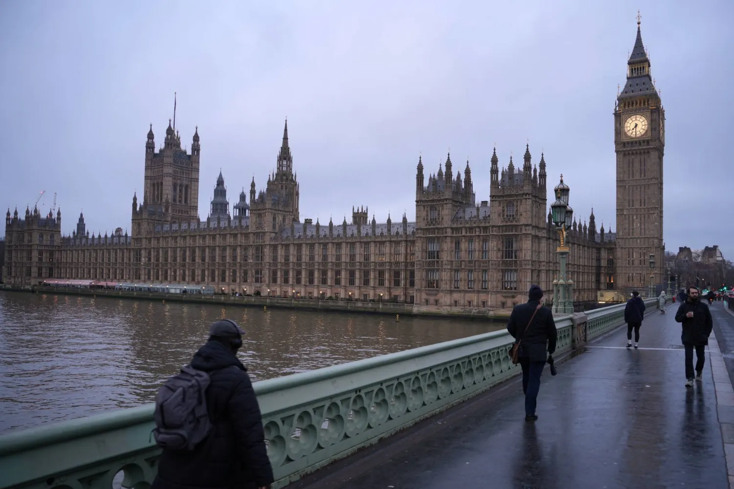 Pedestrians cross Westminster Bridge in front of Parliament during the early morning hours in London, Tuesday, Feb. 10, 2026.(AP Photo/Kin Cheung)