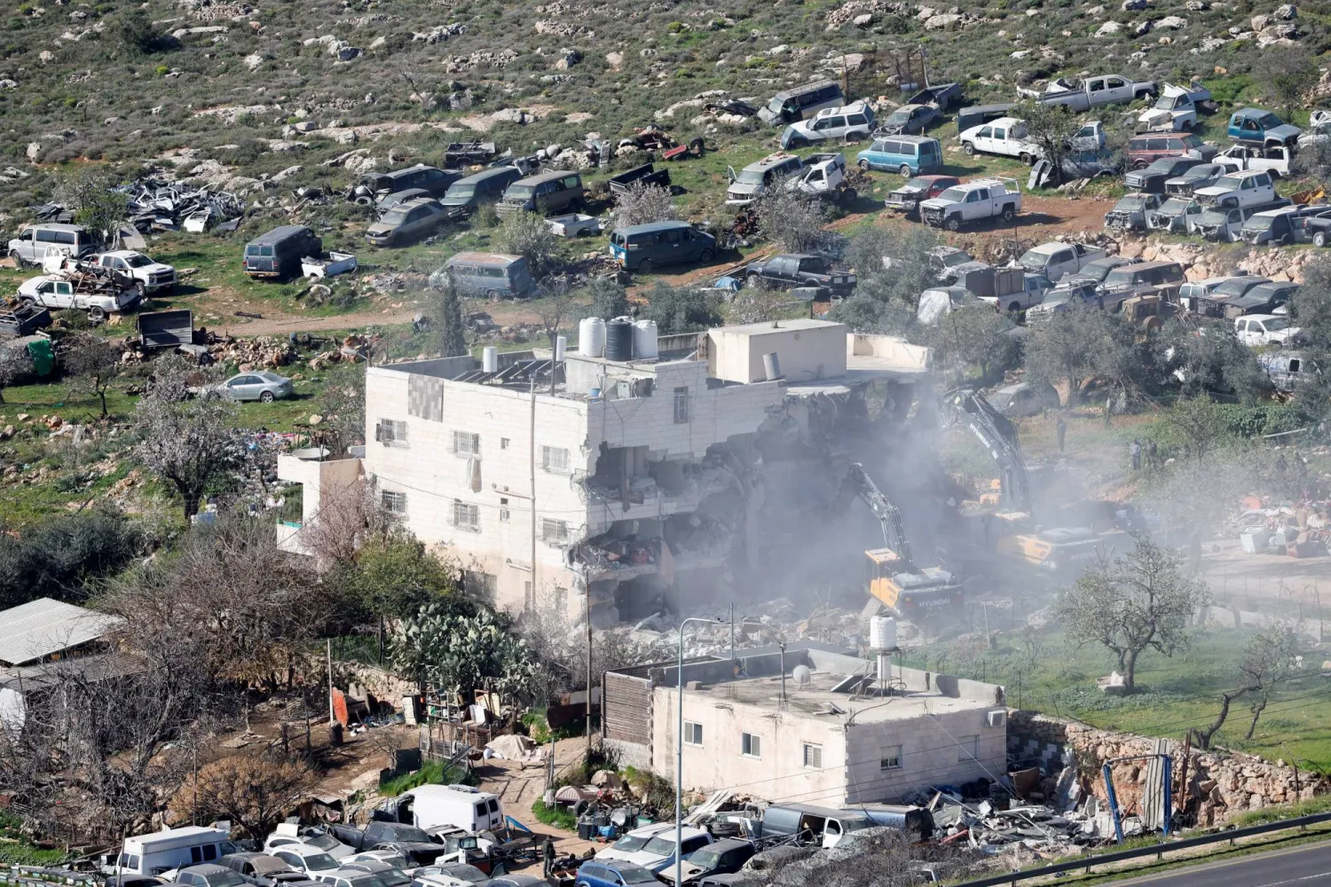 آليات ثقيلة تهدم مبنى فلسطينياً قرب الخليل في الضفة الغربية (رويترز)