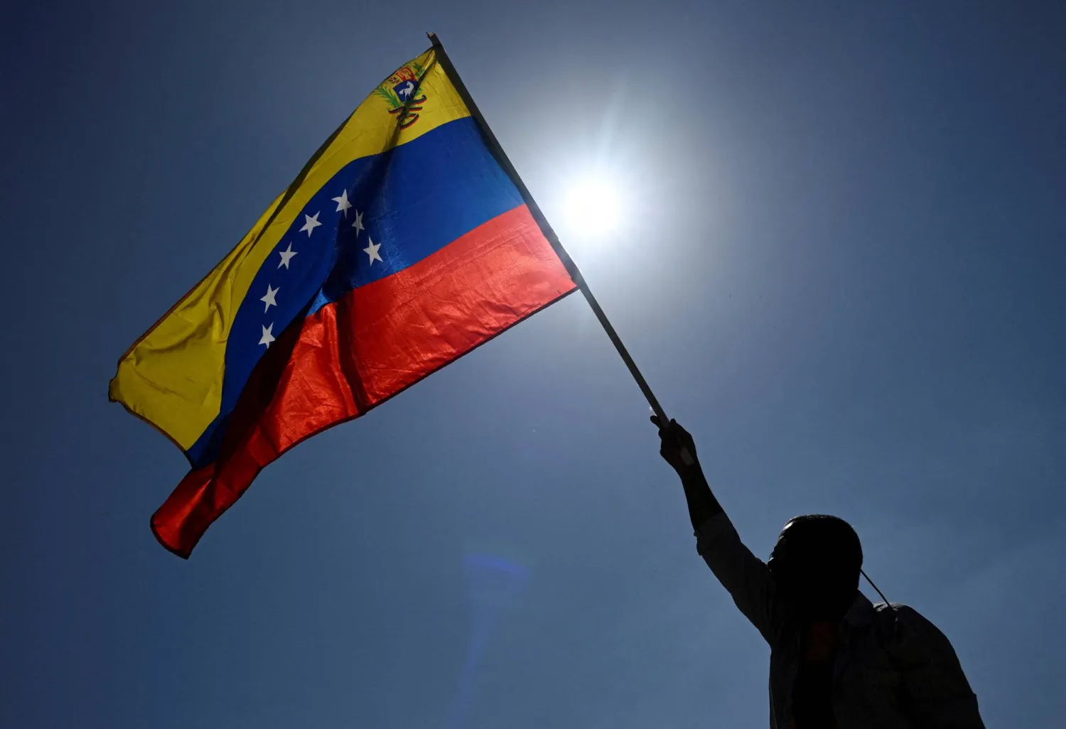 A man holds up a Venezuelan flag while taking part in a march calling for amnesty for political prisoners and to mark Youth Day, in Caracas, Venezuela, February 12, 2026. (Reuters)