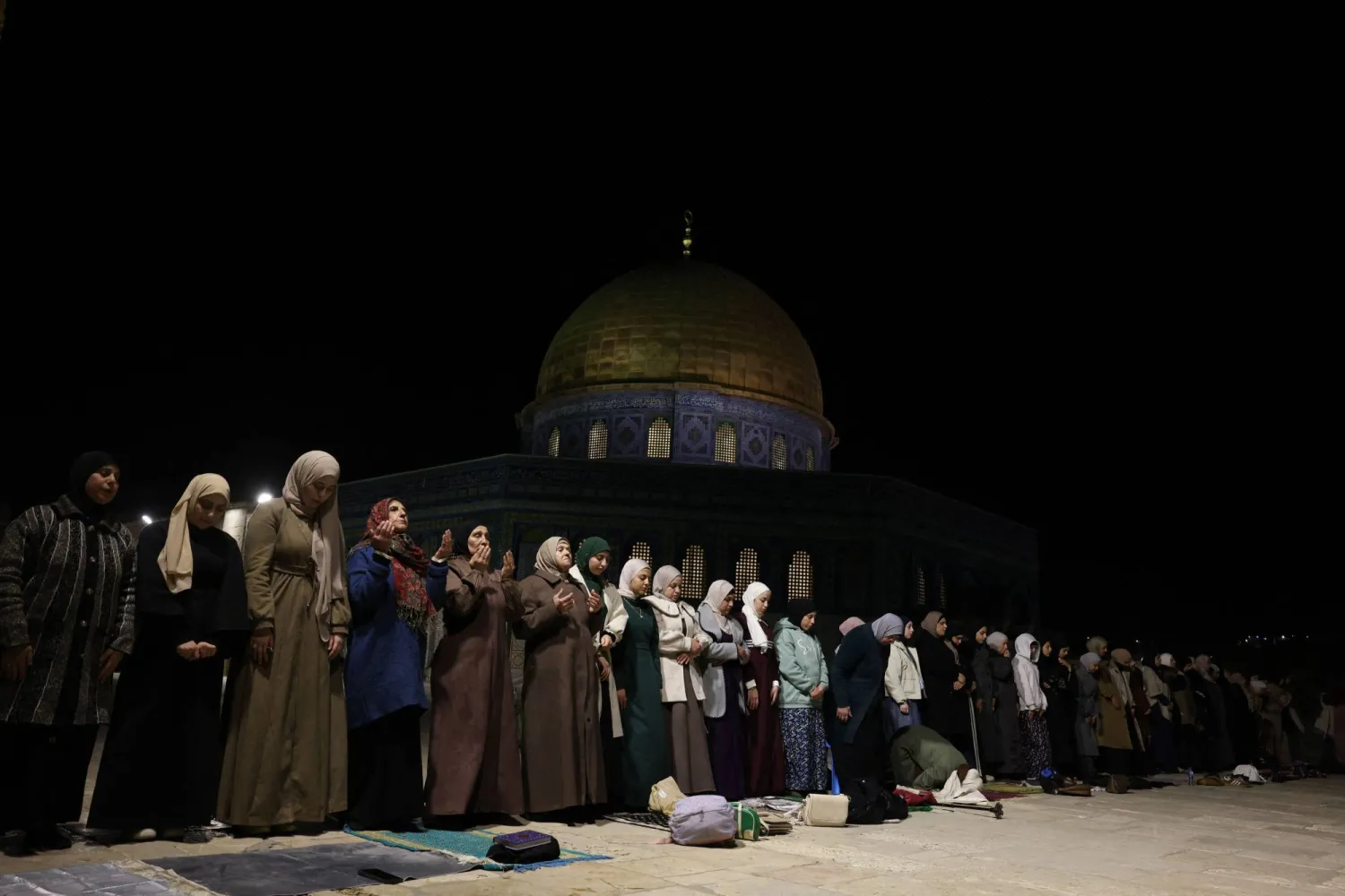 تؤدي نساء فلسطينيات صلاة التراويح في الليلة الأولى من شهر رمضان المبارك قرب قبة الصخرة في المسجد الأقصى بالبلدة القديمة في القدس (أ.ف.ب)