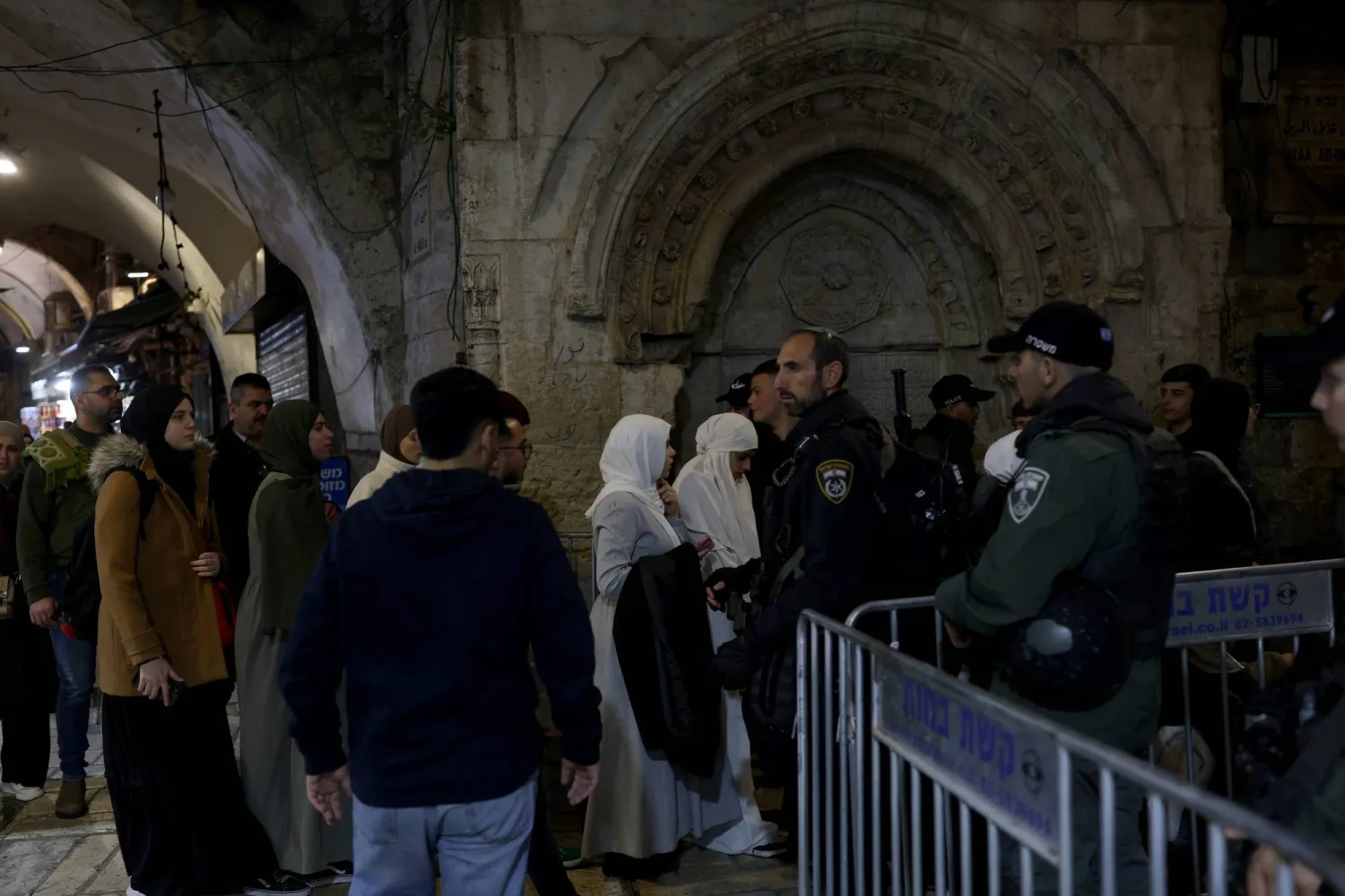 فلسطينيون في أزقة البلدة القديمة بينما تنشر الشرطة الإسرائيلية قوات معززة (إ.ب.أ)