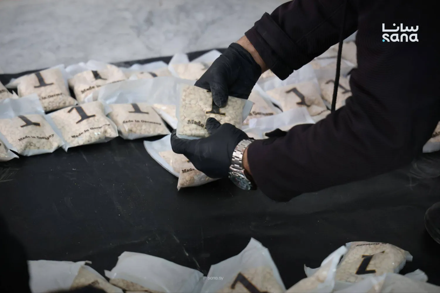 رجل أمن سوري يتفحص المخدرات التي ضبطت في عملية تهريب خارج سوريا (الداخلية السورية)