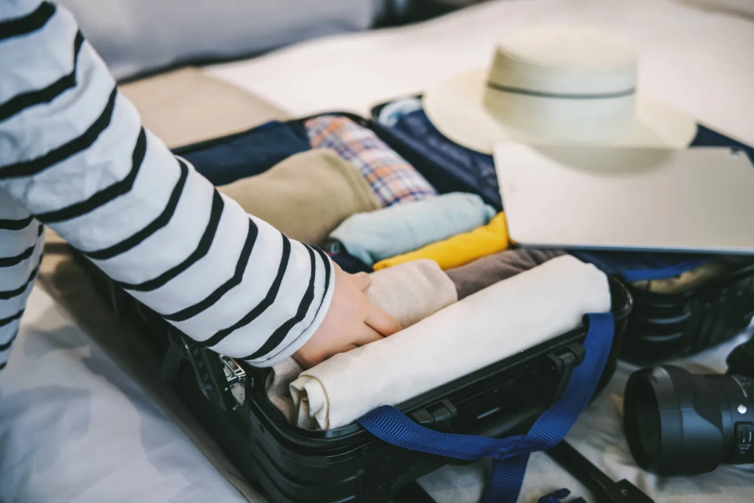 لف الملابس طريقة جيدة لتوضيب حقيبة السفر (شاترستوك)