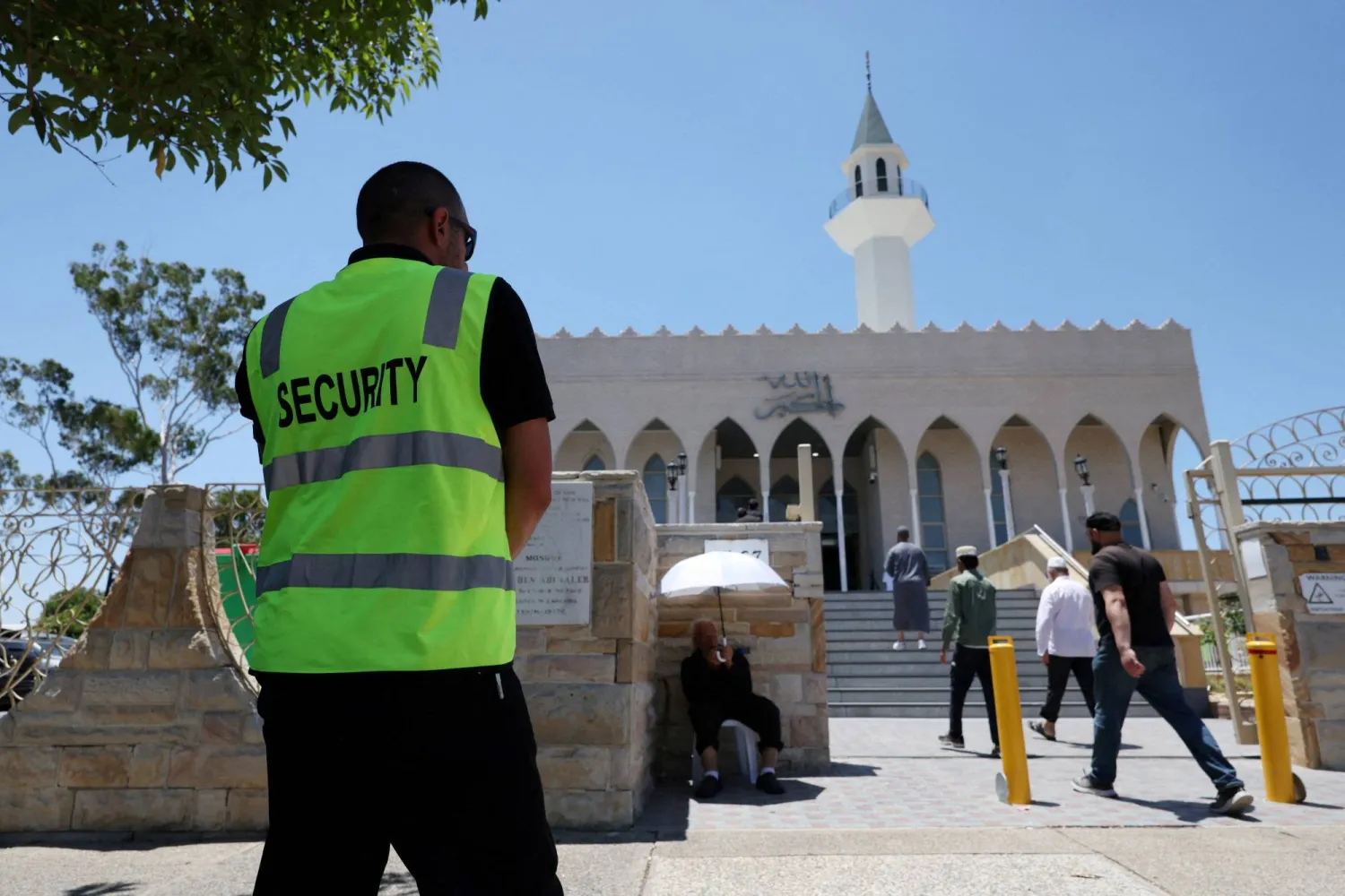 FILE PHOTO: A security guard stands outside the Lakemba Imam Ali bin Abi Talib Mosque as people arrive for Friday prayers in Sydney, Australia, December 19, 2025. REUTERS/Hollie Adams/File Photo