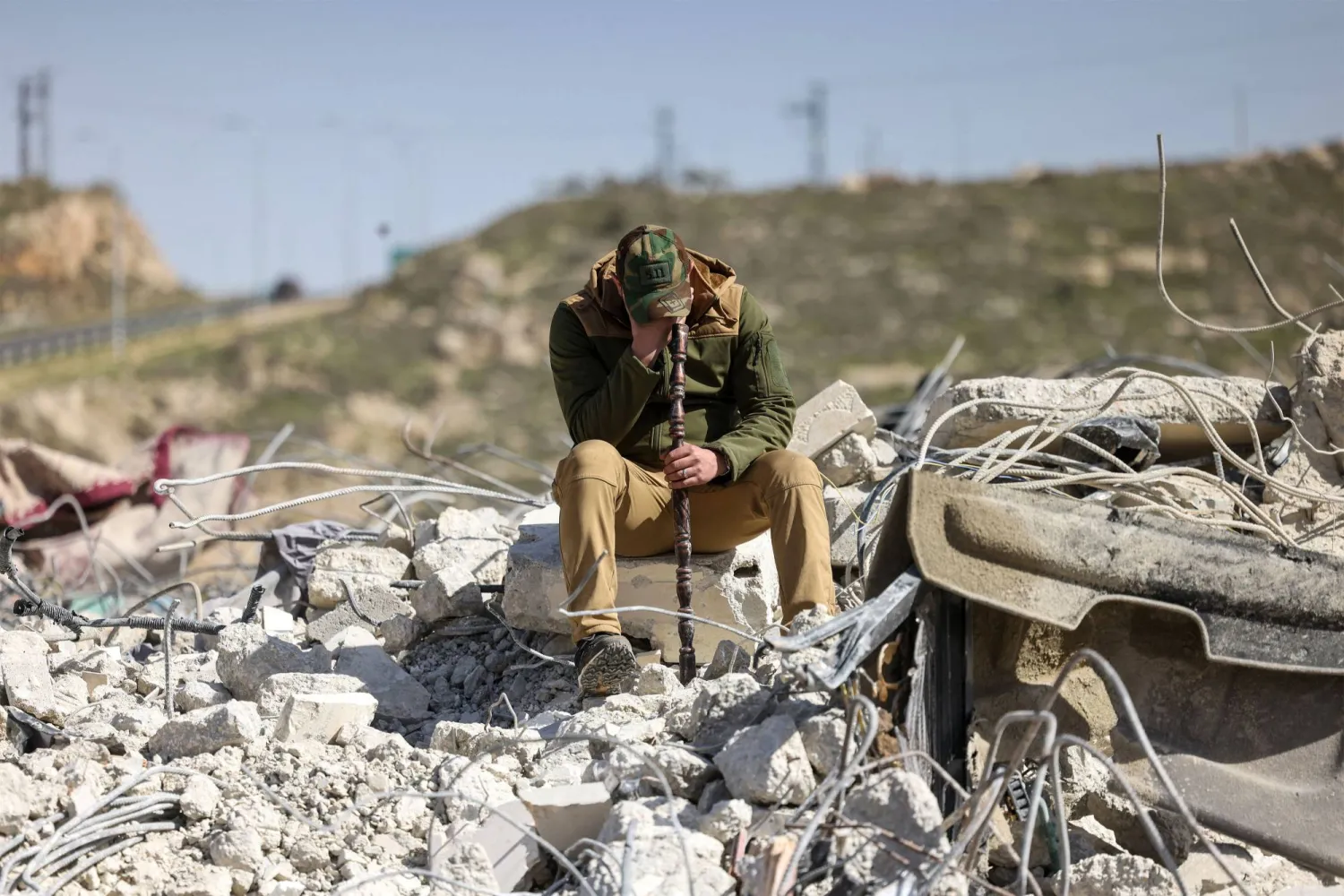 A member of the Salhab family weeps as he sits on the on the rubble of apartment building after it was demolished by Israeli bulldozers near the Israeli settlement of Hagai, south of the occupied West Bank city of Hebron, on February 18, 2026. (Photo by HAZEM BADER / AFP)