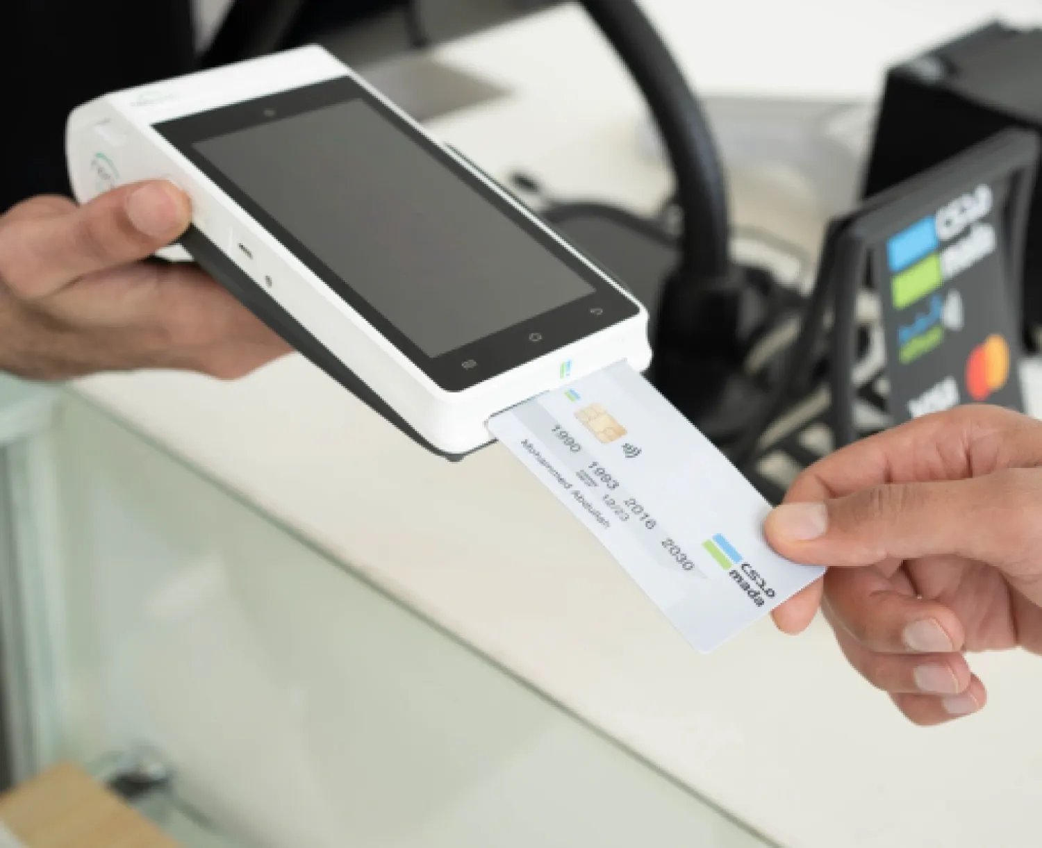أحد الأشخاص يستخدم بطاقة «مدى» لدفع مبلغ مالي عبر جهاز نقاط البيع (مدى)
