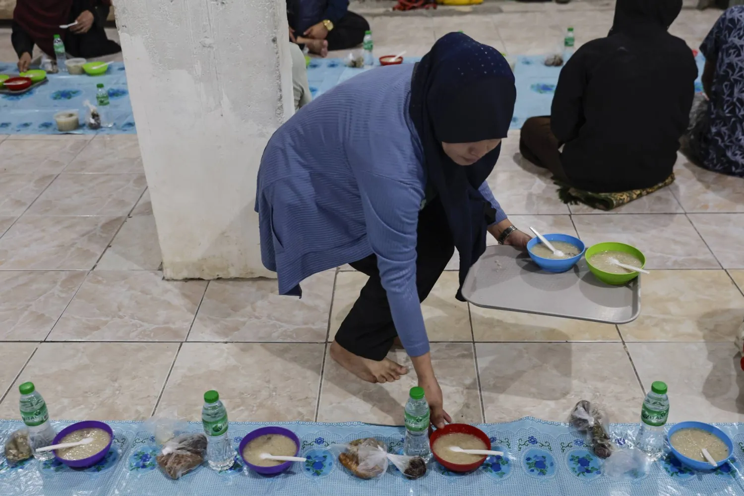 سيدة تُجهز وجبات الإفطار في أحد مساجد مانيلا بالفلبين (إ.ب.أ)