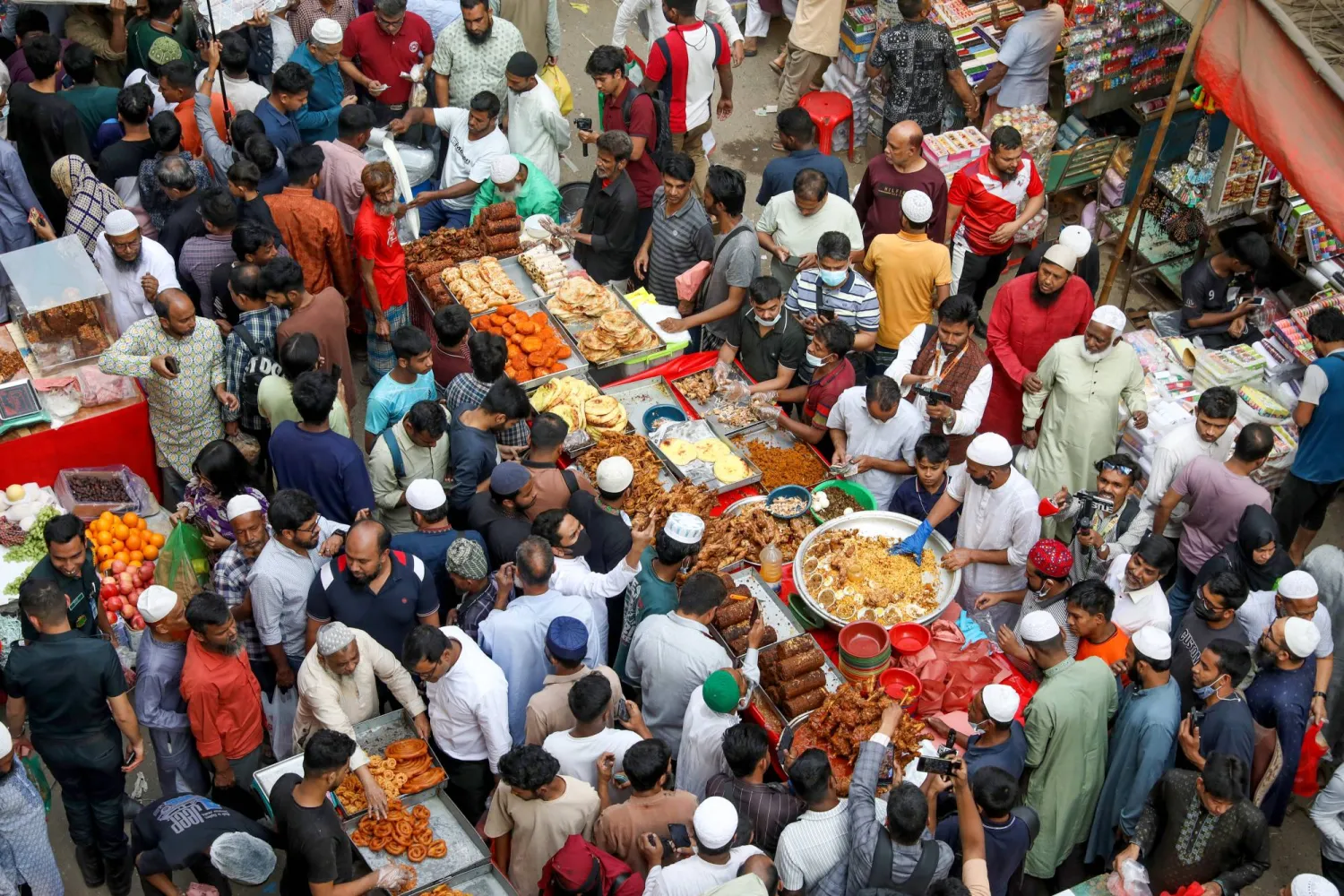في بنغلاديش احتشد الصائمون قبل وقت الإفطار بالأسواق لشراء الأطعمة التقليدية والحلويات (إ.ب.أ)