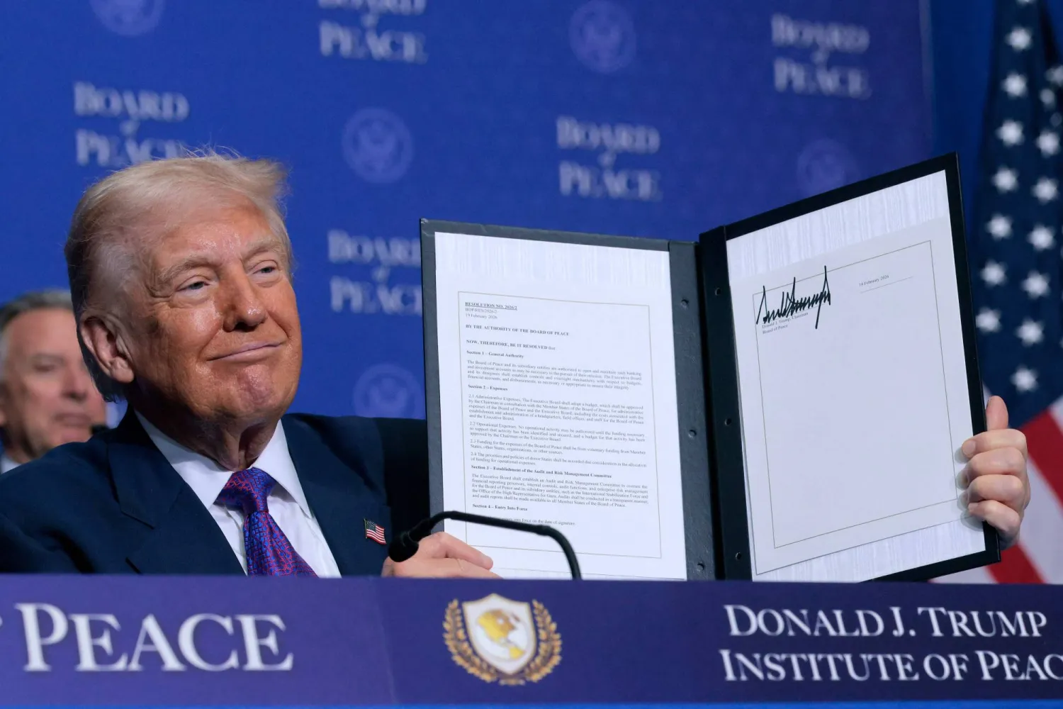 الرئيس الأميركي دونالد ترمب يحمل مذكرة تفاهم وقع عليها خلال اجتماع «مجلس السلام» في واشنطن الخميس (أ.ف.ب) 