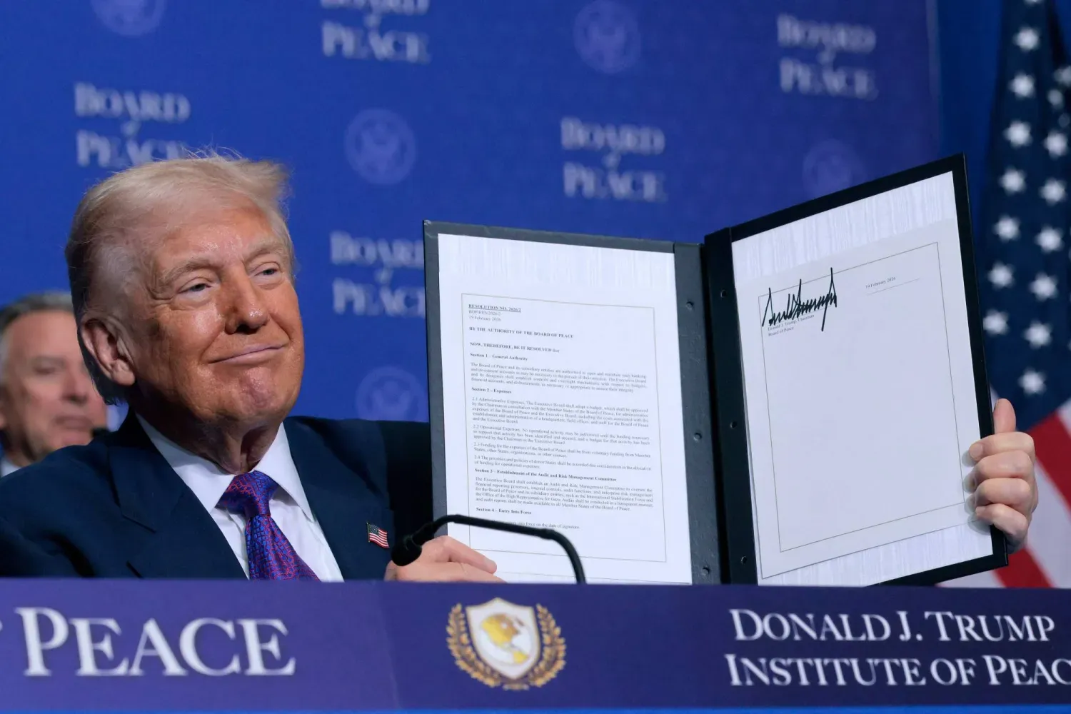 ABD Başkanı Donald Trump, Perşembe günü Washington’da düzenlenen “Barış Konseyi” toplantısında imzalanan mutabakat zaptını elinde tutarken (AFP)