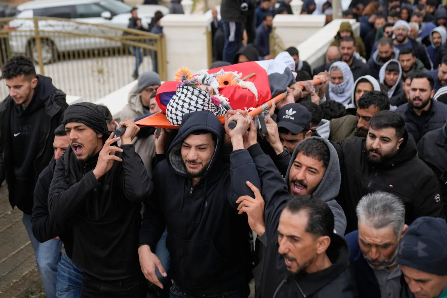 Mourners carry the body of Palestinian-American Nasrallah Muhammad Jamal Abu Siyam, 19, who according to the Palestinian Health Ministry was shot by settlers on Wednesday night, during his funeral in the West Bank village of Mukhmas, east of Ramallah, Thursday, Feb. 19, 2026. (AP Photo/Nasser Nasser)
