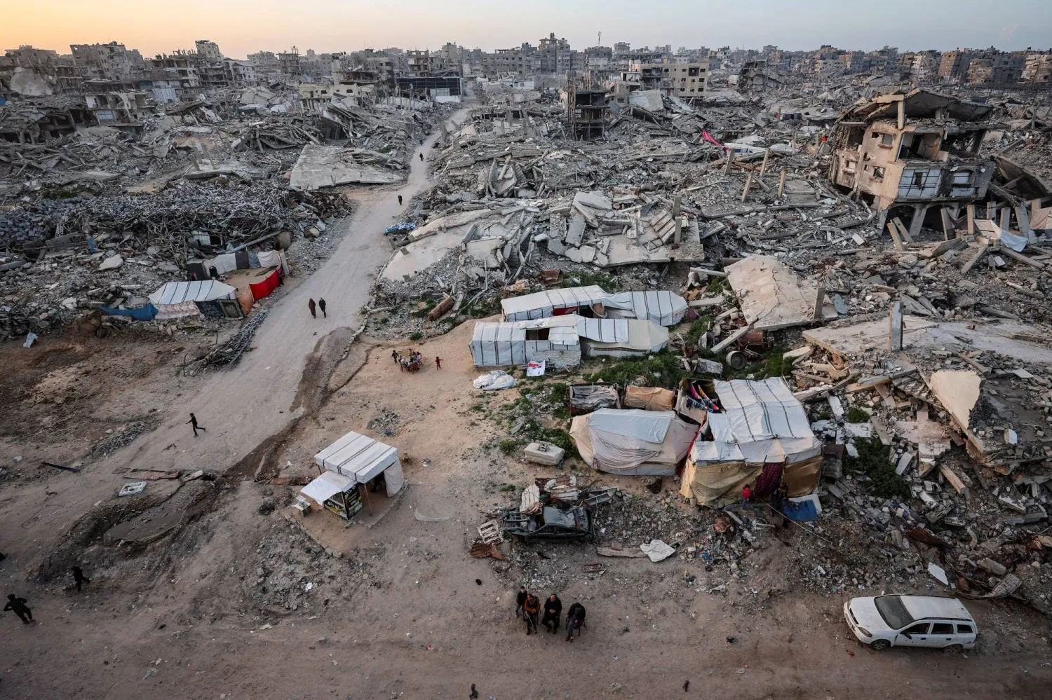 فلسطينيون يتجمعون قرب أنقاض مبانٍ سكنية دُمرت خلال الهجوم الإسرائيلي الذي استمر عامين في أول أيام شهر رمضان المبارك في مدينة غزة 18 فبراير 2026 (رويترز)
