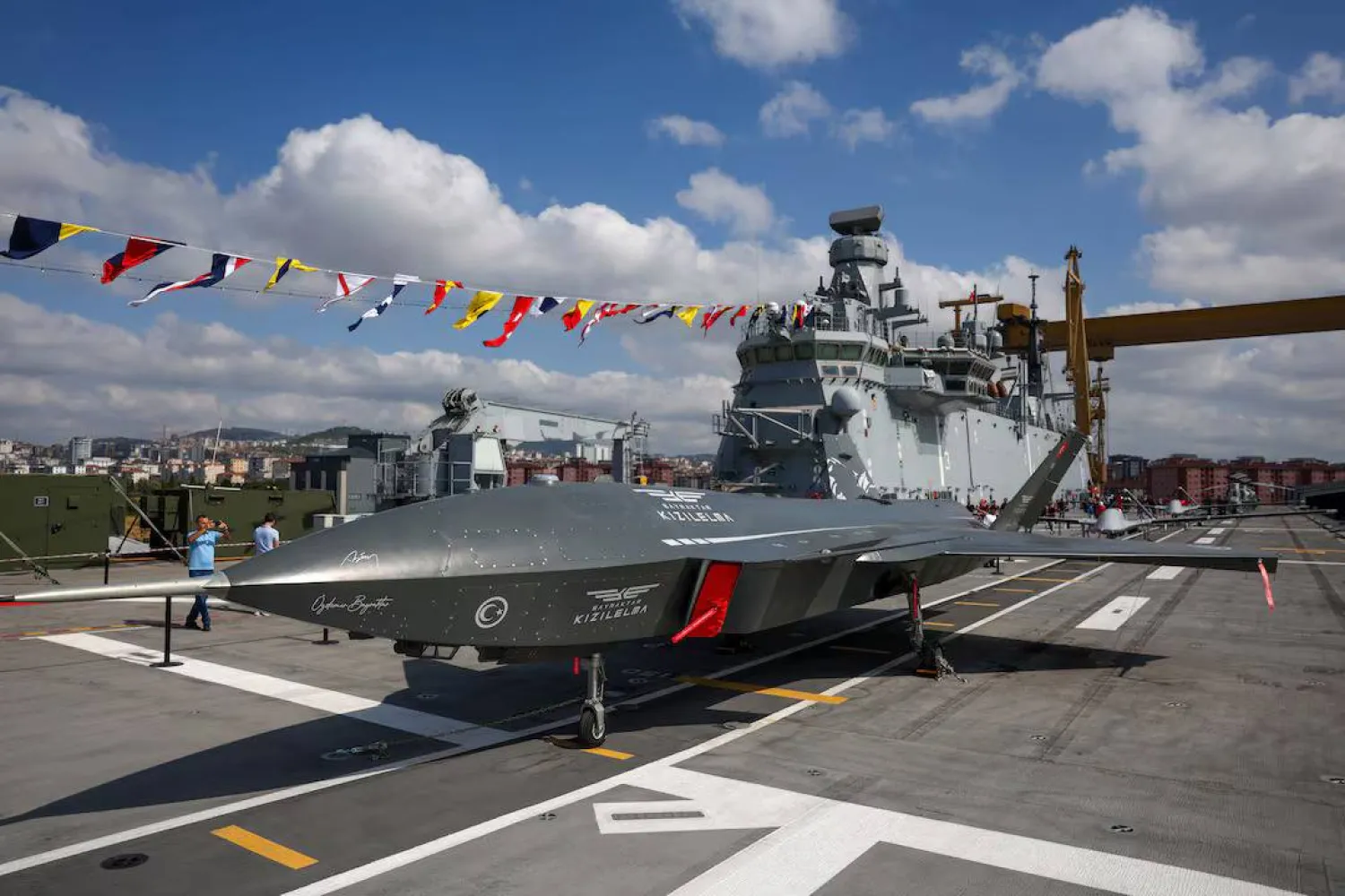 طائرة «كيزيليما» المقاتلة المسيّرة على سطح سفينة «تي سي جي أناضولو» أول سفينة هجومية برمائية تركية إلى جانب طائرات مسيّرة أخرى ومروحيات عسكرية في قيادة حوض بناء السفن البحرية في إسطنبول يوم 29 أغسطس 2025 (رويترز)