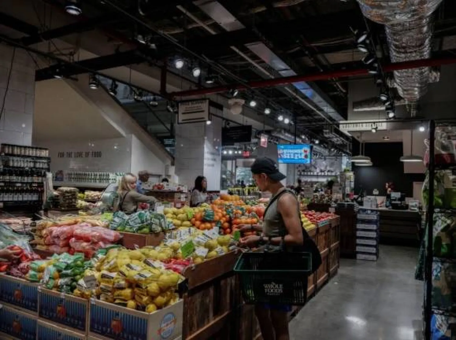 يتسوَّق أشخاص لشراء البقالة في أحد المتاجر بمدينة نيويورك (رويترز)
