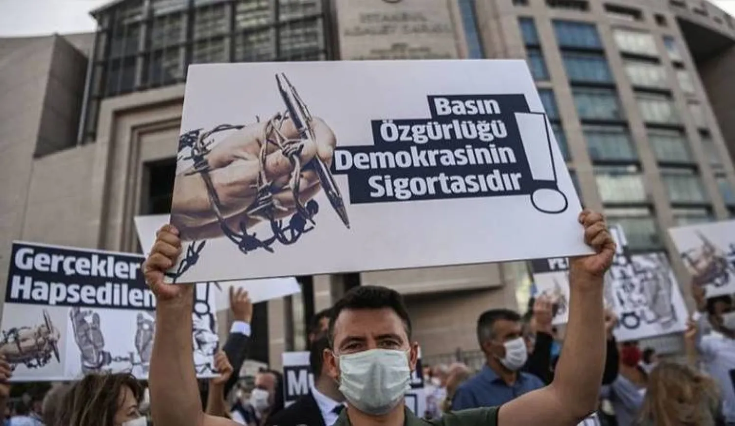 صحافيون يضعون كمامات على أفواههم خلال مظاهرة أمام مجمع محاكم تساغليان في إسطنبول احتجاجاً على اعتقالات زملائهم والمطالبة بحرية الصحافة (أ.ف.ب)