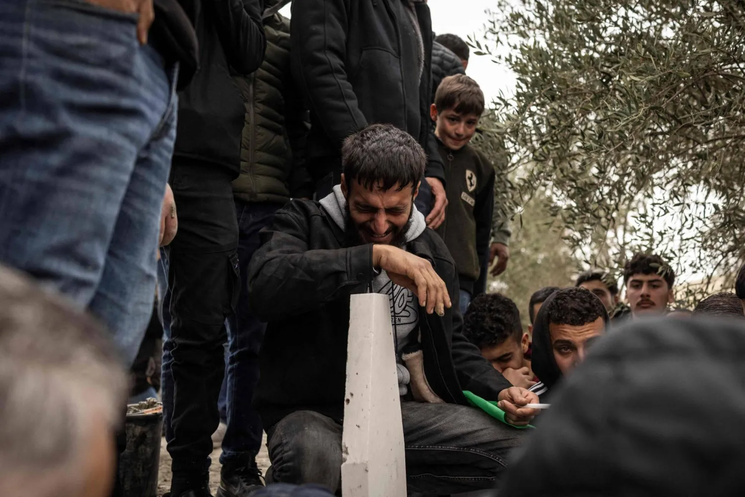 أقارب شاب فلسطيني أميركي قتله مستوطن إسرائيلي في قرية مخماس بالضفة الغربية خلال تشييع جثمانه (أ.ف.ب)