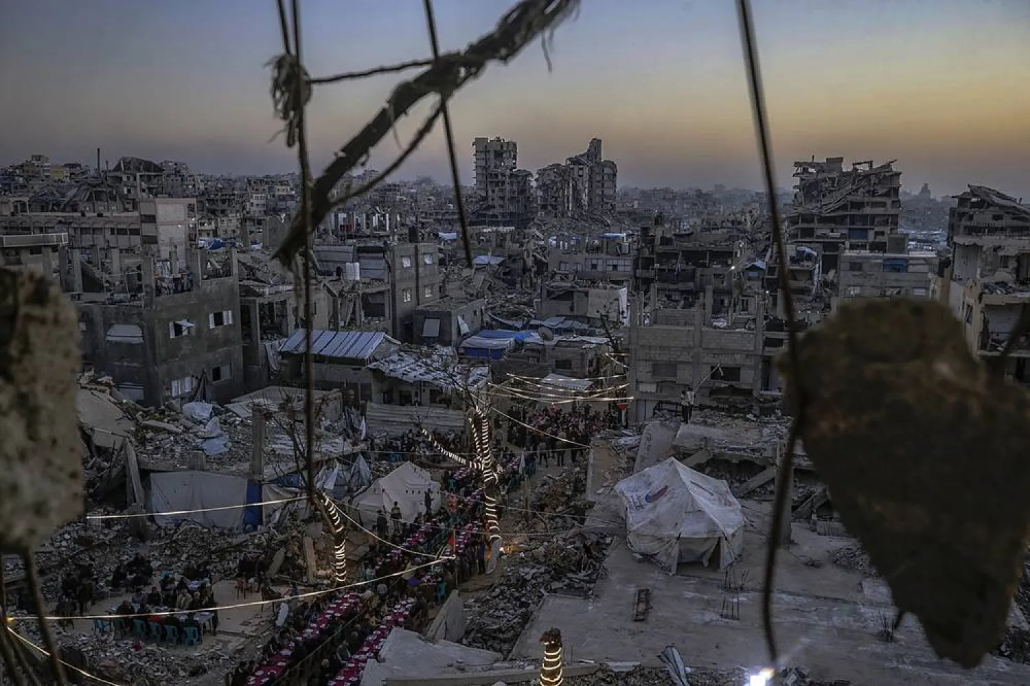 Palestinians gather between destroyed houses to break their fast together during the holy month of Ramadan in the northern Gaza Strip, 20 February 2026. (EPA)