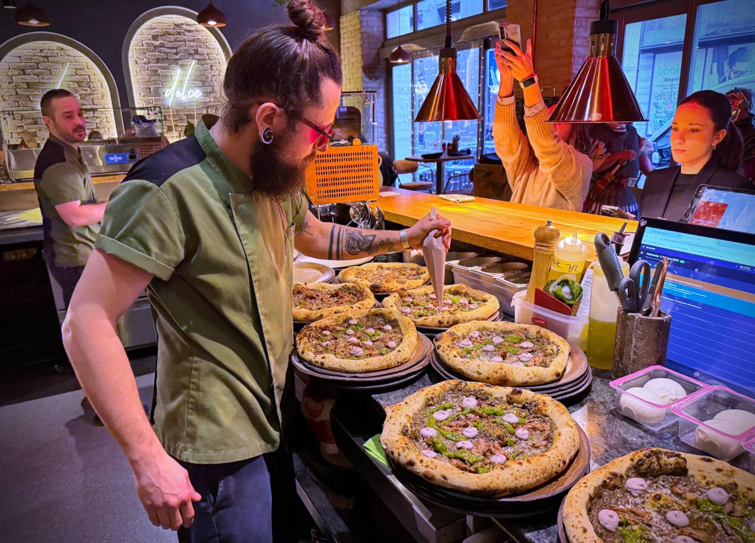 László Bárdossy, head chef of the Neverland Pizzeria adds topping on the restaurant's Roman-era pizza in Budapest, Hungary, on Feb. 11, 2026. (AP) 