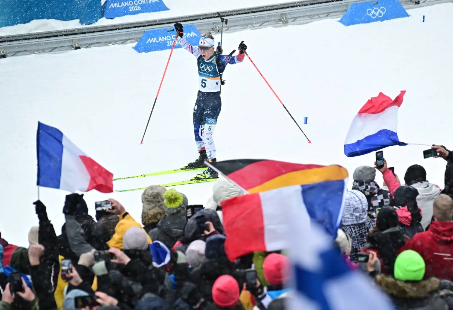 أوسيان ميشلون تحتفل مع الجماهير الفرنسية بذهبية الانطلاق الجماعي (إ.ب.أ)