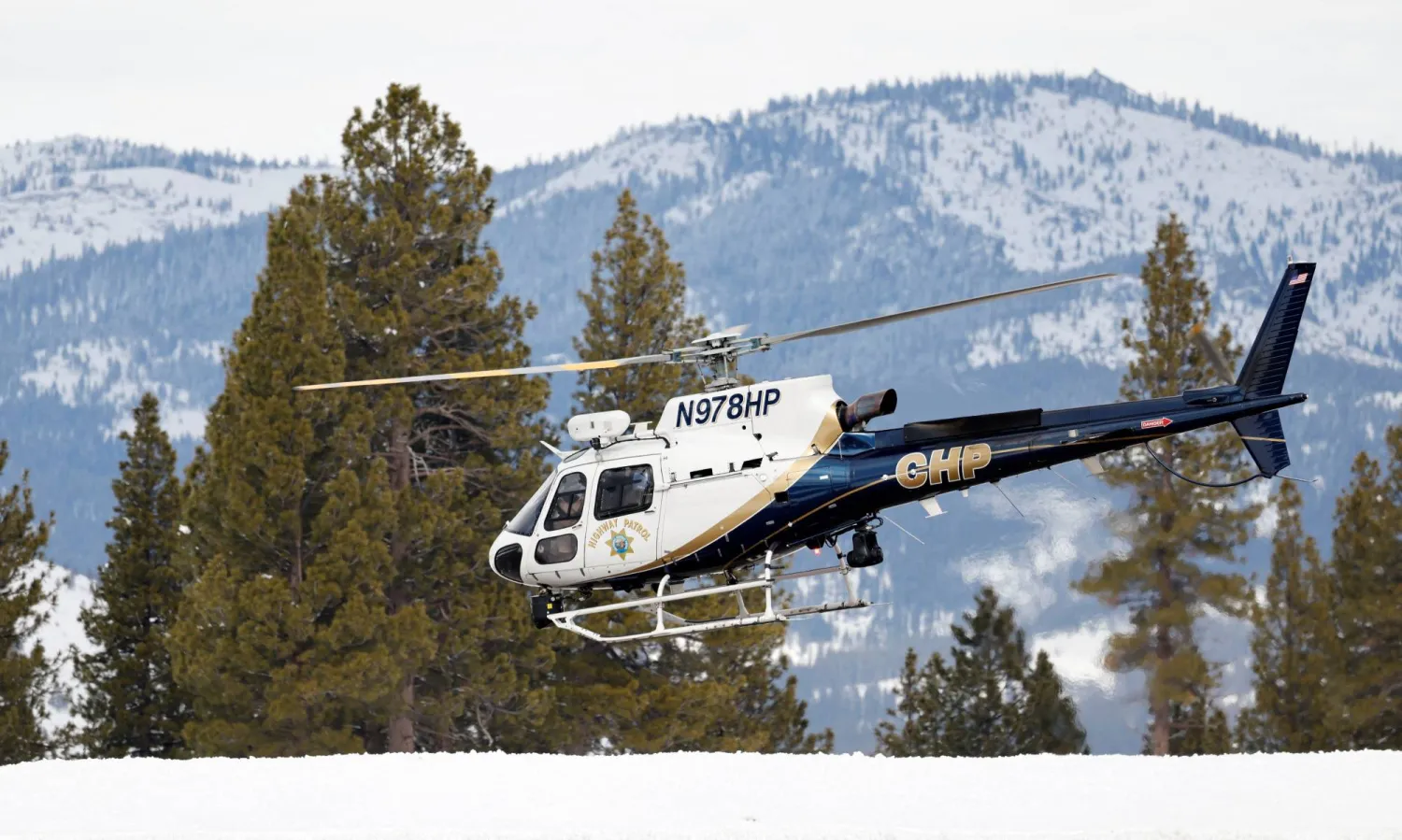 A California Highway Patrol helicopter lifts off from Truckee Tahoe Airport while taking part in recovery efforts for the skiers that died in an avalanche in the Sierra Nevada mountains, in Truckee, California, US February 21, 2026.  REUTERS/Fred Greaves