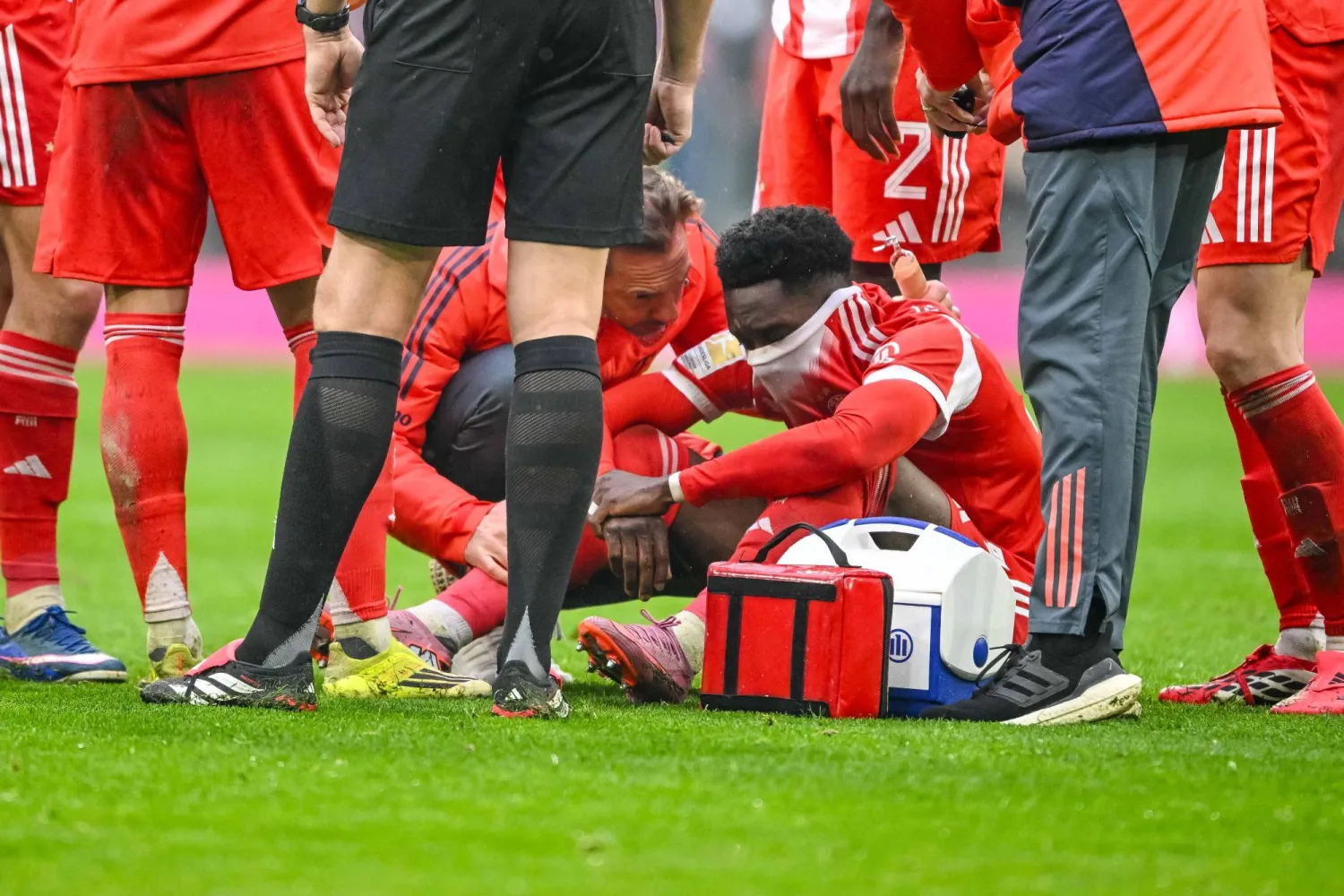 21 February 2026, Bavaria, Munich: Bayern Munich's Alphonso Davies (R) sits injured on the ground during the German Bundesliga soccer match between Bayern Munich and Eintracht Frankfurt at Allianz Arena. Photo: Harry Langer/dpa 