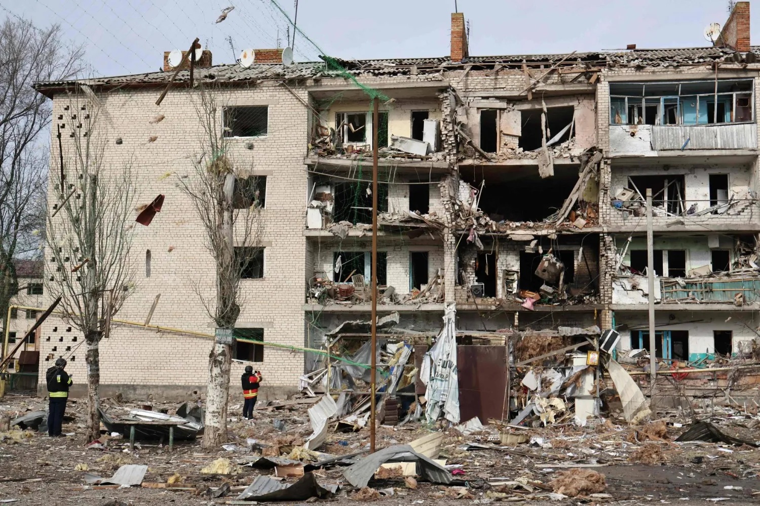 تظهر هذه الصورة التي التقطها ونشرها المكتب الصحافي لـ«اللواء الآلي 65» التابع للقوات المسلحة الأوكرانية يوم 20 فبراير 2026 عناصر إنفاذ القانون الأوكرانيين وهم يقفون بين الأنقاض أمام مبنى سكني متضرر عقب غارة جوية في كوميشوفاخا بمنطقة زابوريجيا (أ.ف.ب)