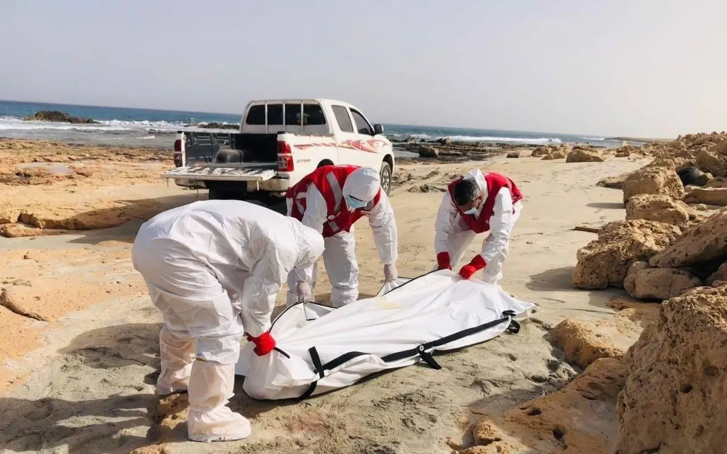 Libya Kızılayı mensupları, Zaviye şehrindeki sahilden kimliği belirsiz bir ceset çıkarıyor (Libya Kızılayı, Facebook üzerinden)