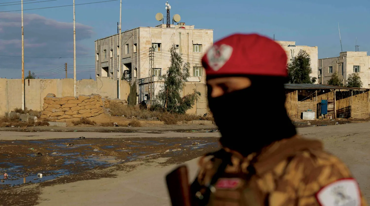 A Syrian government soldier outside Al-Aqtan prison in Raqqa, which holds ISIS detainees (AFP)