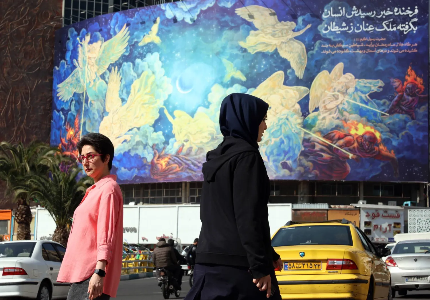 Iranians walk past a huge billboard carrying a poem interpretation in Persian 'Human will defeat the evils' at Valiasr Square in Tehran, Iran, 21 February 2026. EPA/ABEDIN TAHERKENAREH