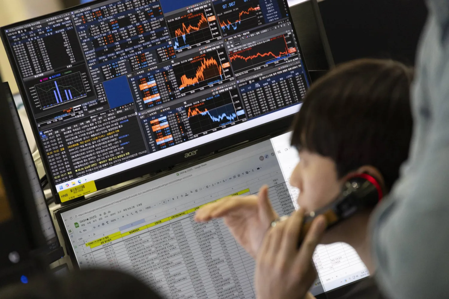 متداول كوري جنوبي يعمل أمام شاشات تعرض مؤشرات الأسهم ببنك هانا في سيول (إ ب أ)