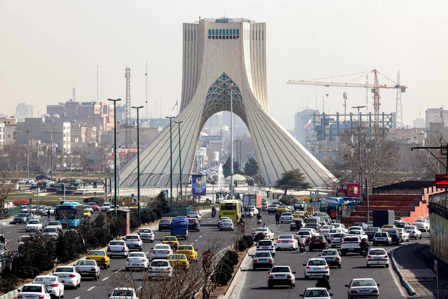 Vehicles move along a highway near Tehran's landmark Azadi (Freedom) Tower in Tehran on February 23, 2026. (Photo by ATTA KENARE / AFP)