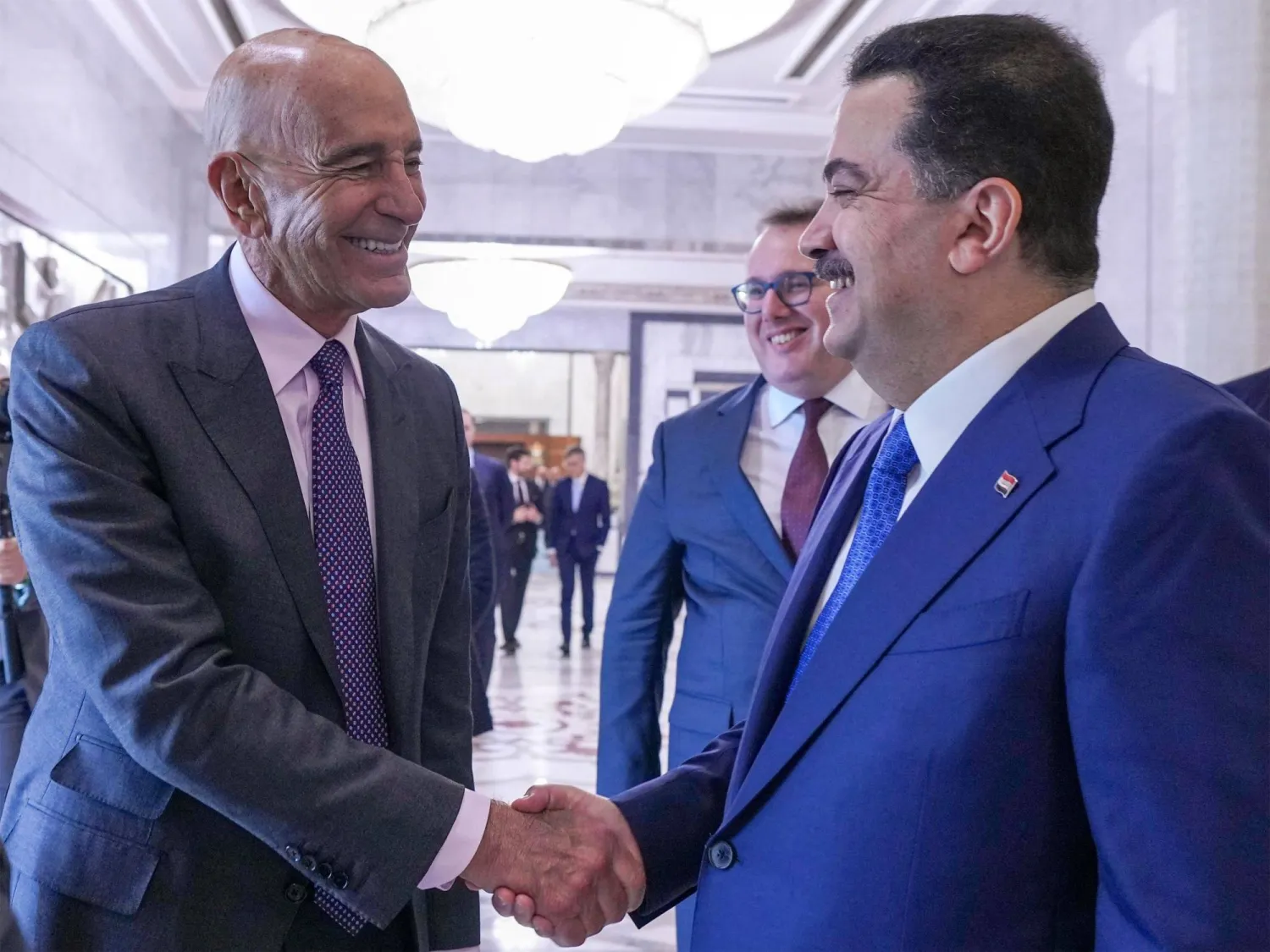 This handout picture made available by the Iraqi prime minister's office shows Iraq's Prime Minister Mohammed Shia al-Sudani (R) receiving US Special Envoy to Iraq Tom Barrack (L) before attending the signing of agreements between Chevron Corporation and the Basra, Dhi Qar, and North Oil Companies at the government palace in Baghdad on February 23, 2026. (Iraqi Prime Minister’s Press Office / AFP)  