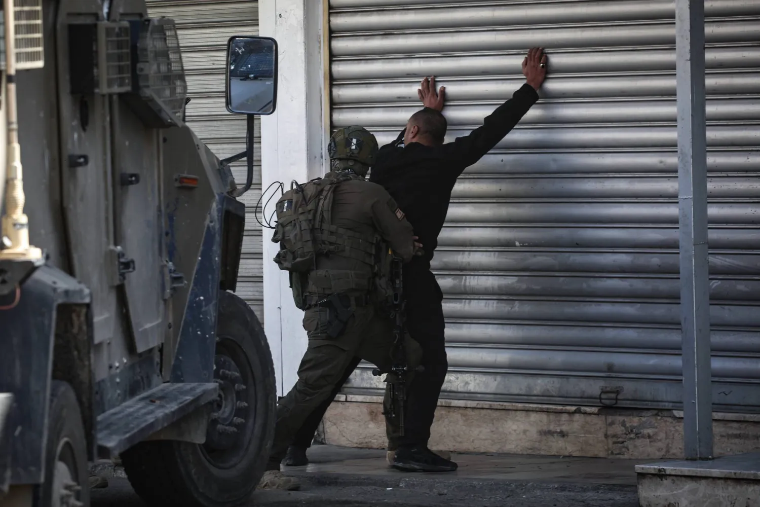 جندي إسرائيلي يفتش فلسطينياً خلال اقتحام القوات الإسرائيلية مخيماً قرب نابلس بالضفة الغربية (أرشيفية - د.ب.أ)