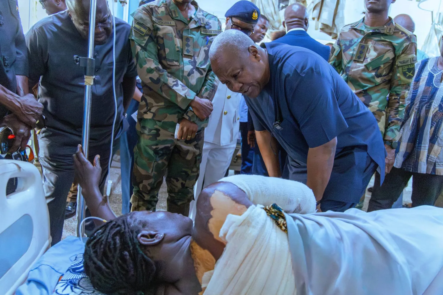 الرئيس الغاني جون ماهاما لدى زيارته أحد مواطنيه المصابين في الهجوم الذي شنه متشددون بشمال بوركينا فاسو الأسبوع الماضي (رويترز)