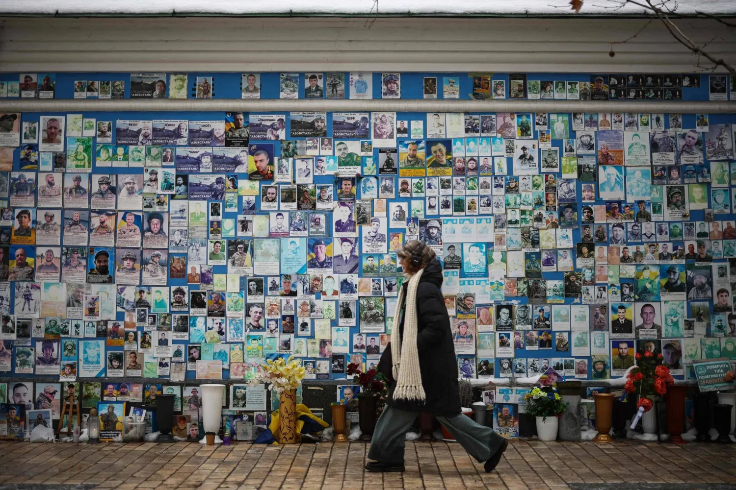 A person walks alongside The Wall of Remembrance of the Fallen for Ukraine in Kyiv on February 23, 2026, as the conflict with Russia reaches its four-year mark. (AFP)