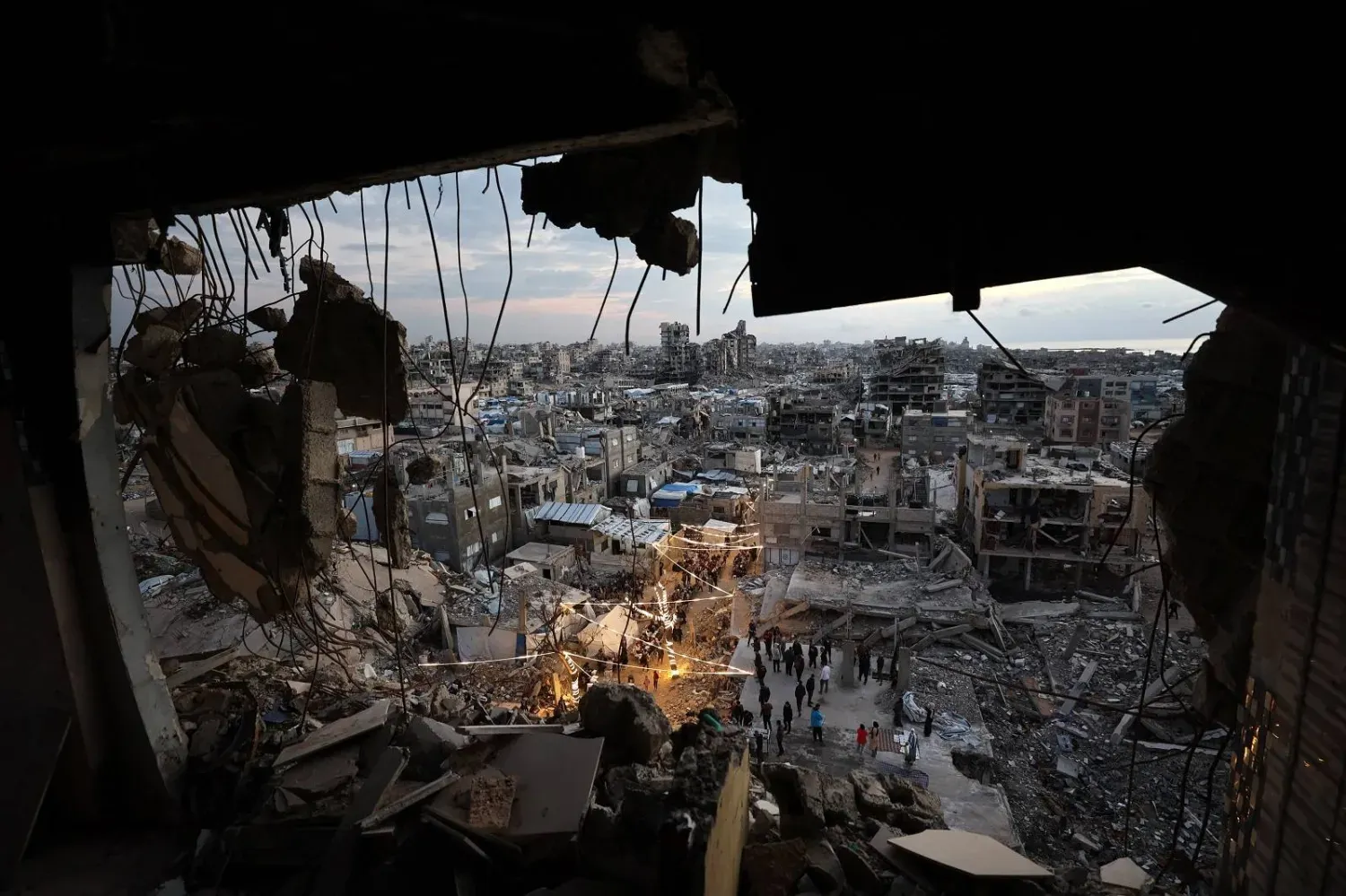 Gazze Şeridi'nin kuzeyindeki Cibaliye Mülteci Kampı’nda yıkılmış binaların enkazı arasında iftar için bir araya gelen yerinden edilmiş Gazzeliler (AFP)