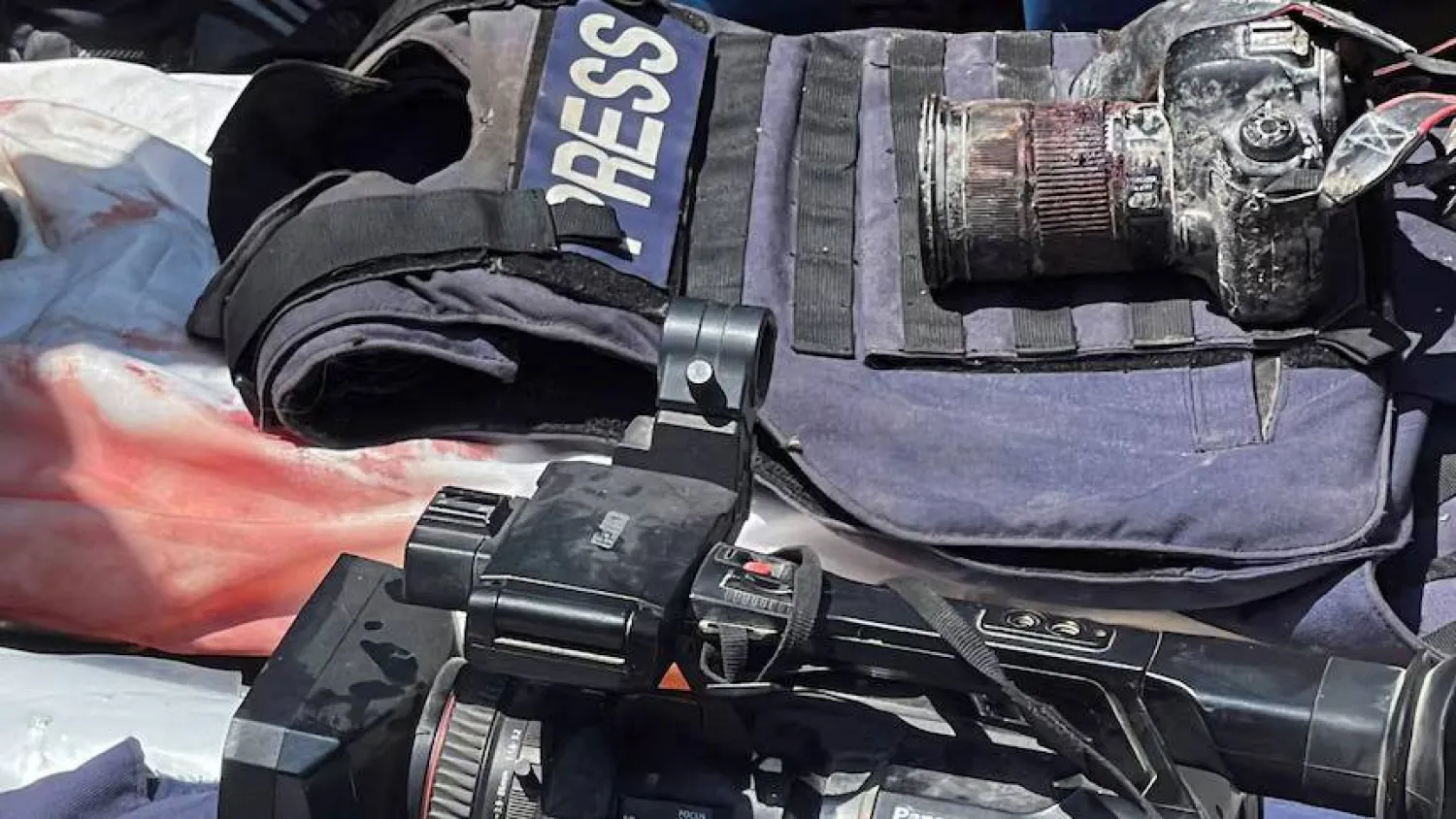 سترات واقية من الرصاص وكاميرات على جثث صحافيين قُتلوا في غزة (رويترز)
