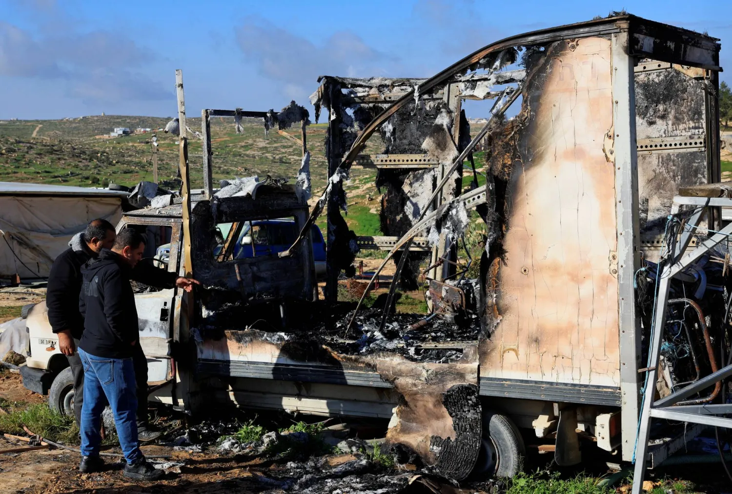  Palestinians check damage to a burned vehicle, which Palestinians say was damaged by Israeli settlers, in Susiya near Hebron in the Israeli-occupied West Bank February 25, 2026. (Reuters)
