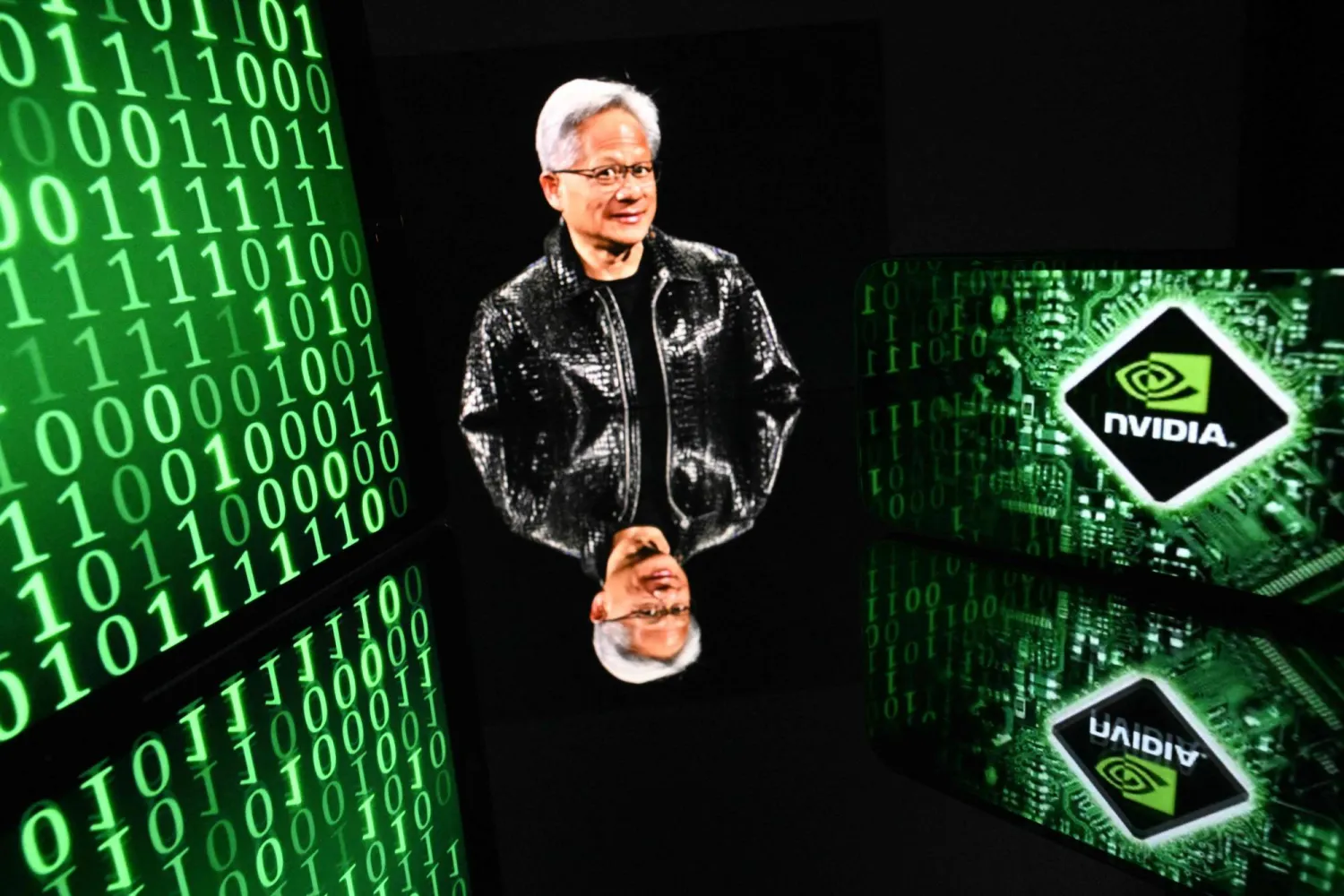 شاشات تعرض صورة رئيس «إنفيديا» جينسين هوانغ وشعار الشركة في تولوز (أ.ف.ب)