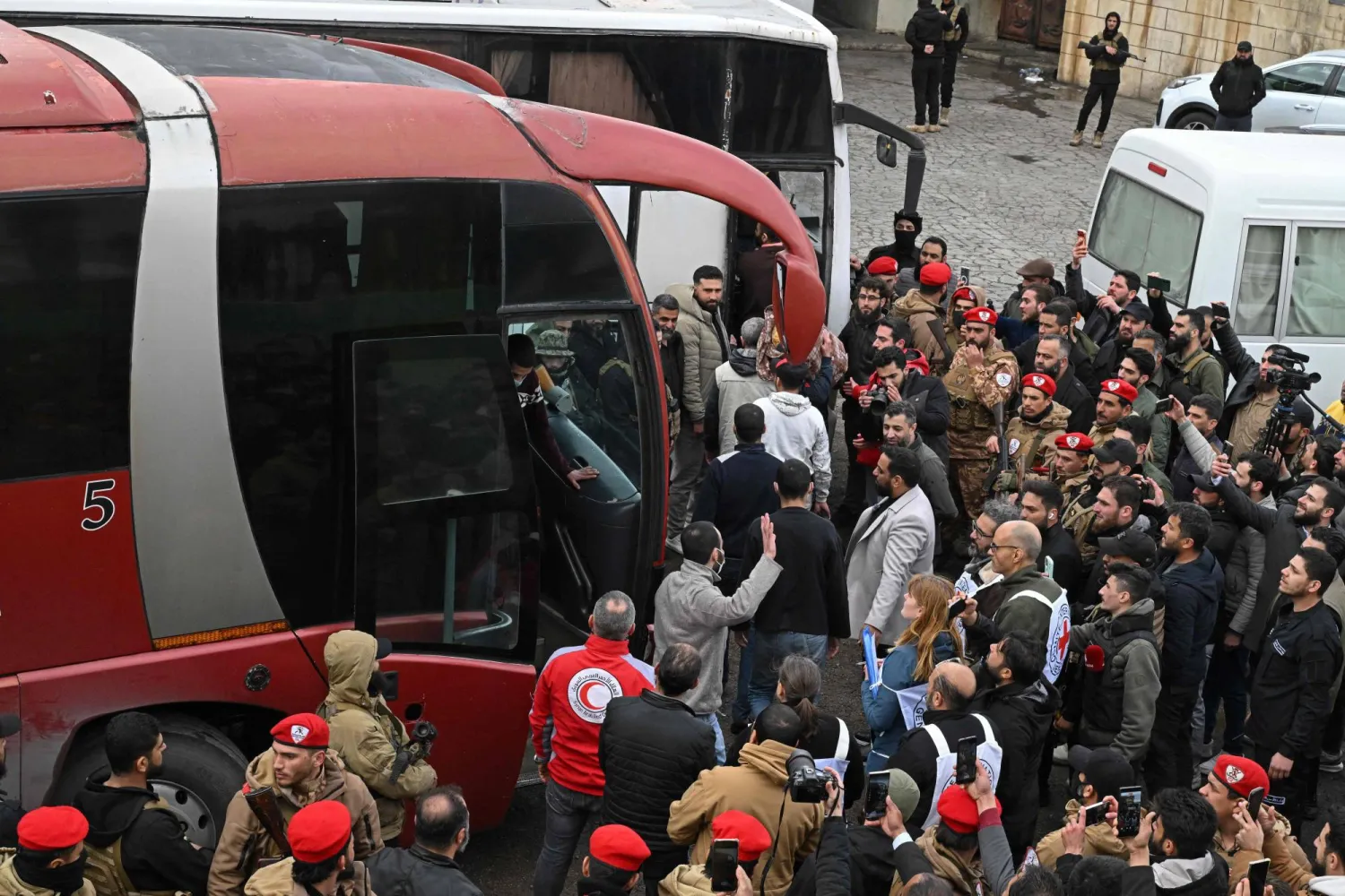 لحظة تبادل السجناء والمخطوفين أمام حافلات خلال مراسم تبادل أسرى بين السلطات السورية ومقاتلين دروز على مشارف السويداء الخميس 26 فبراير (أ.ف.ب)