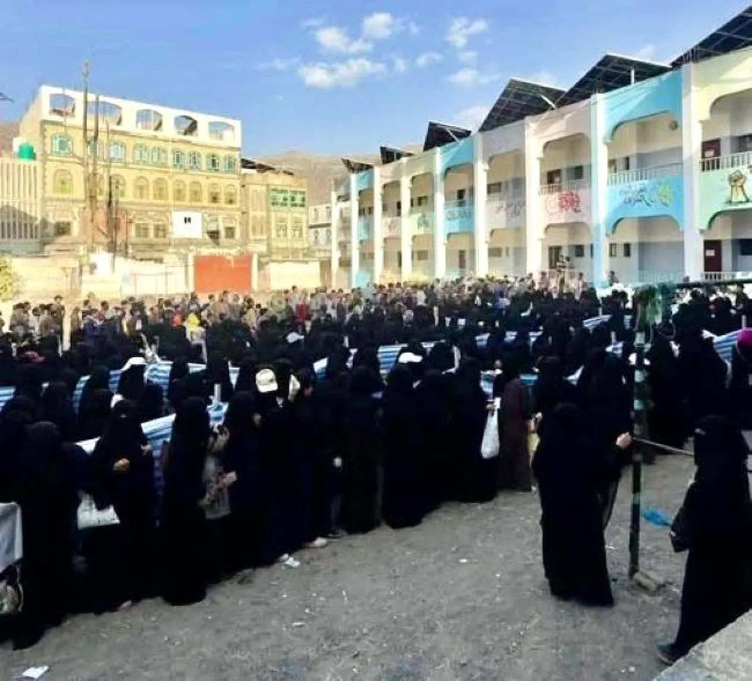  يمنيات يتجمعن في باحة مدرسة حكومية في إب للحصول على وجبة إفطار (فيسبوك)