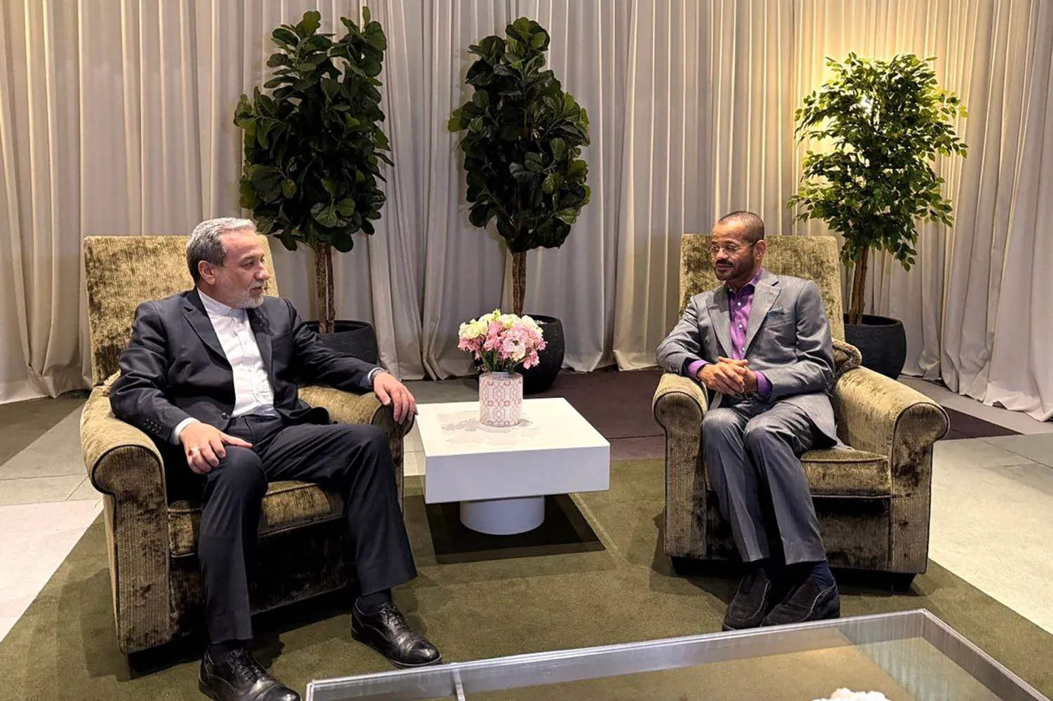 In this handout photo released by the Iranian Foreign Ministry on February 26, 2026, Iran's Foreign Minister Abbas Araghchi (L) speaks with Oman's FM Badr Albusaidi during their meeting in Geneva. (Photo by Iran's Foreign Ministry / AFP)
